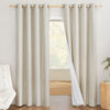 A pair of natural linen blackout curtains with grommets on a rod. One panel is pulled back to show the 100% white blackout liner.
