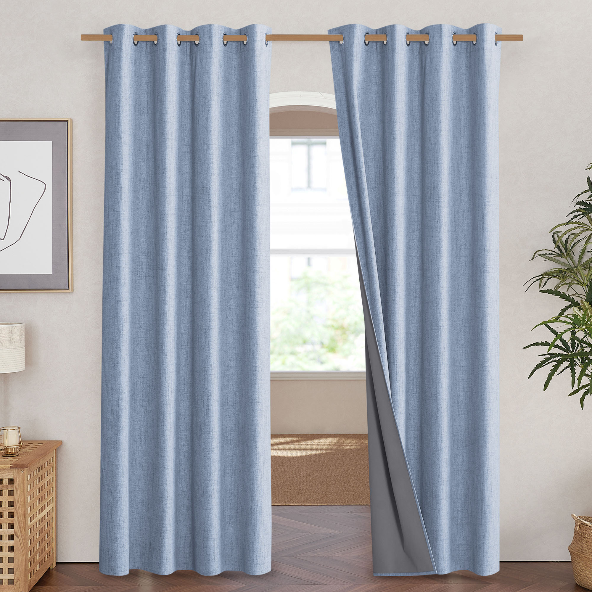 Light blue linen blackout curtains with grommets, with one panel pulled back to show the grey thermal liner.