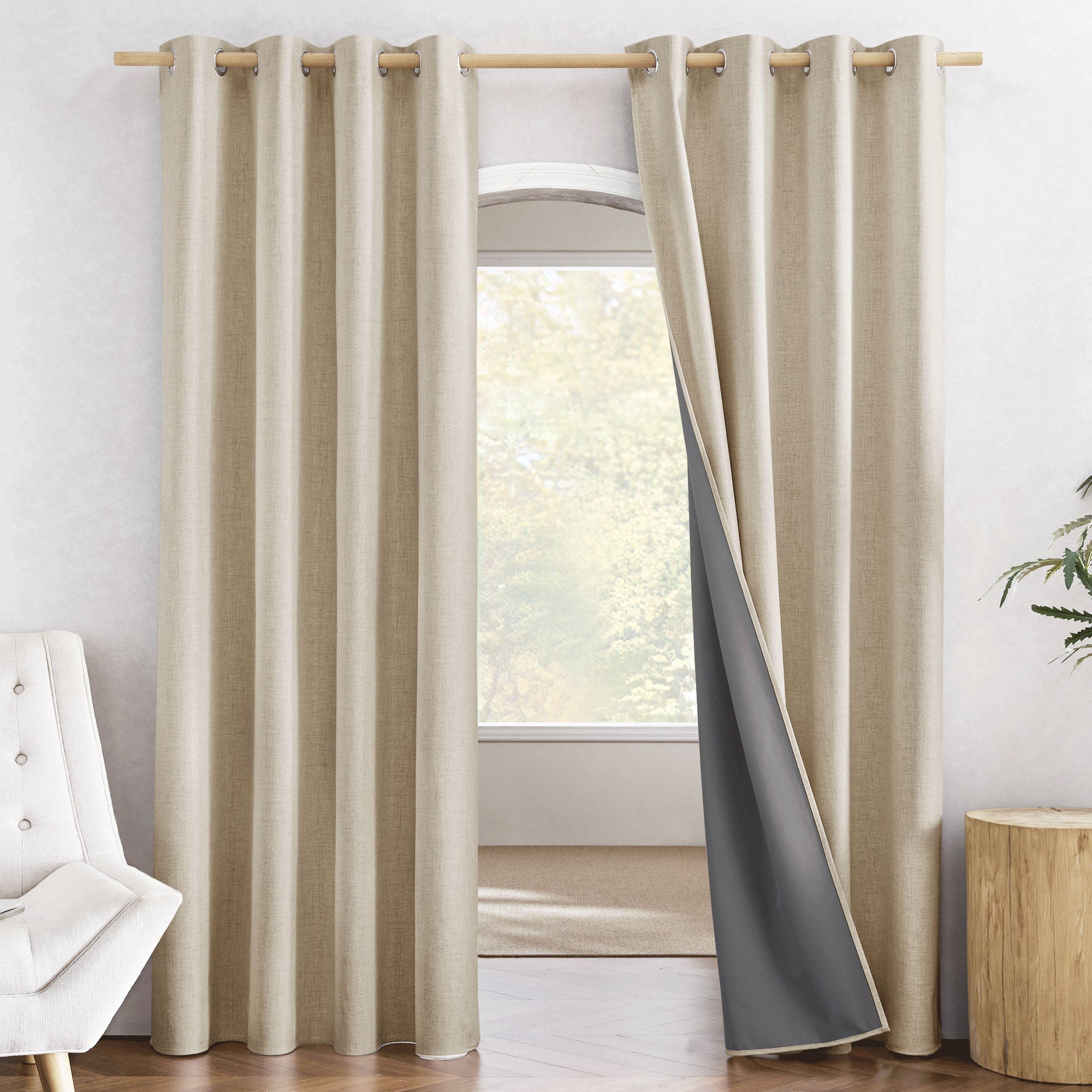 Beige linen curtain panel pulled back to reveal the attached dark grey 100% blackout liner.
