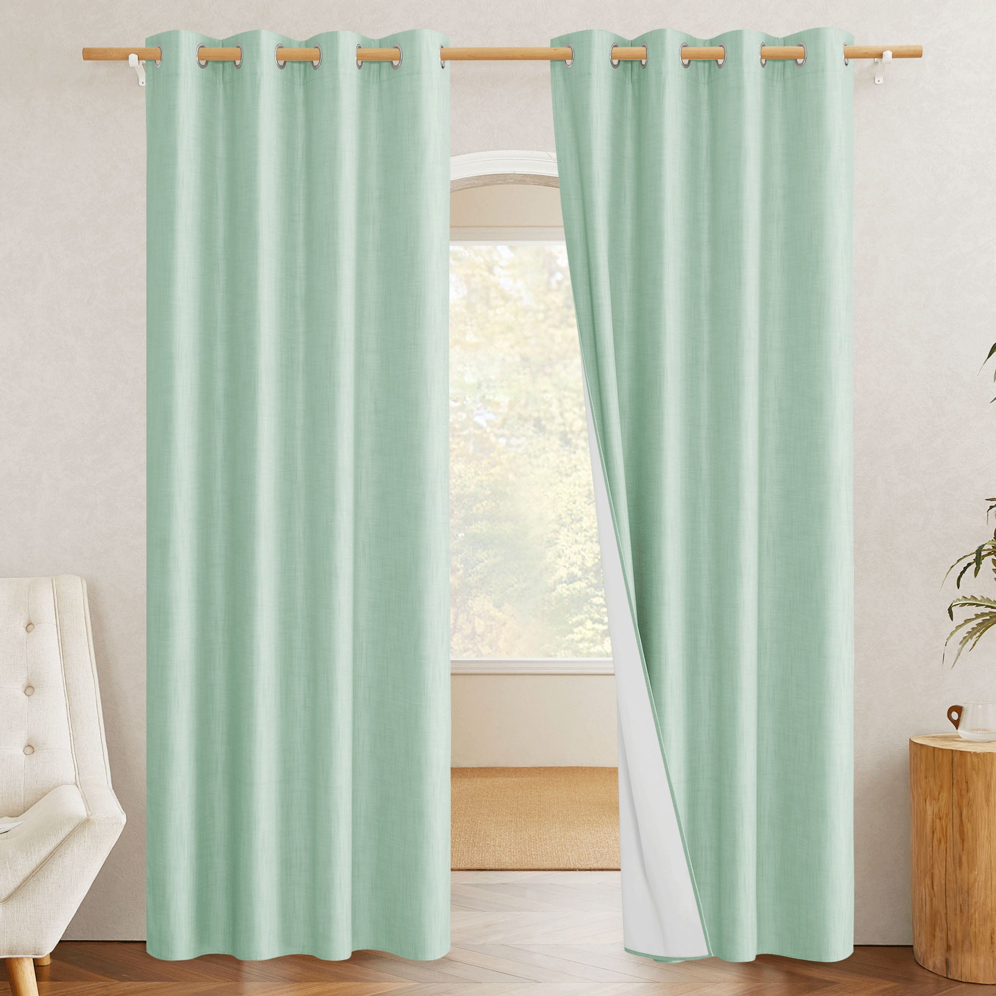 Mint green blackout linen curtains with one panel pulled back to reveal the white 100% blackout liner and silver grommets.