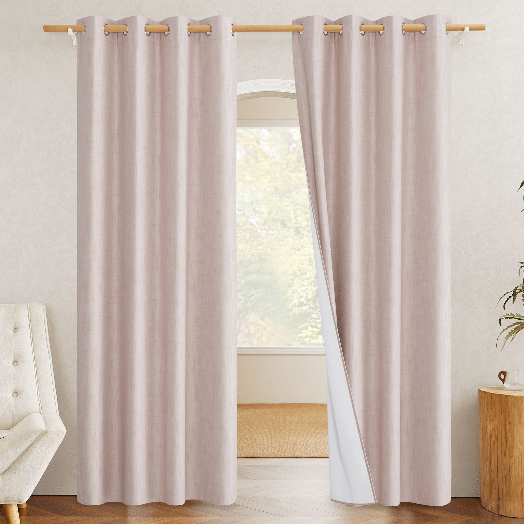 A light pink blackout linen curtain pulled back to show the white 100% blackout lining and silver grommet top construction.