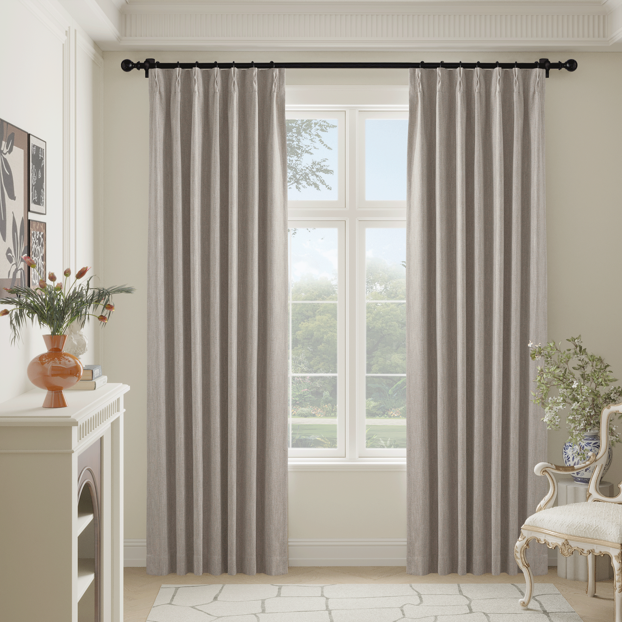 Light natural faux linen full blackout curtains on a black rod in a bright room with a window overlooking a garden.