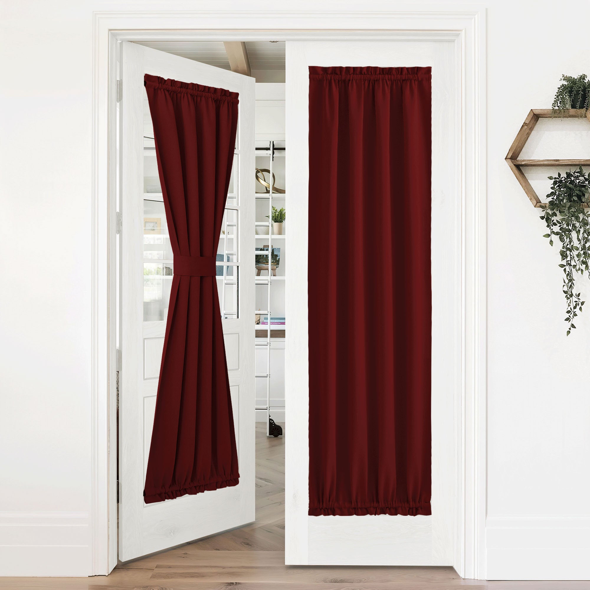 Rich burgundy 50% blackout privacy door curtains on white French doors. One tied back, the other closed for full privacy.