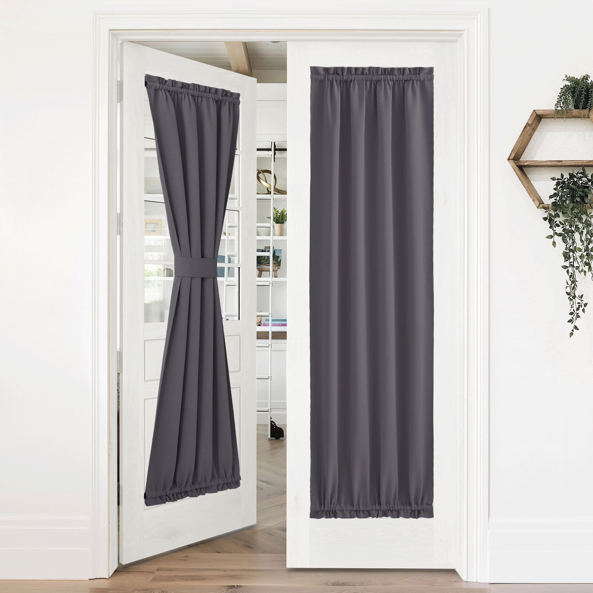 Charcoal grey 50% blackout privacy door curtains on white French doors. One is tied back, the other hangs fully down.