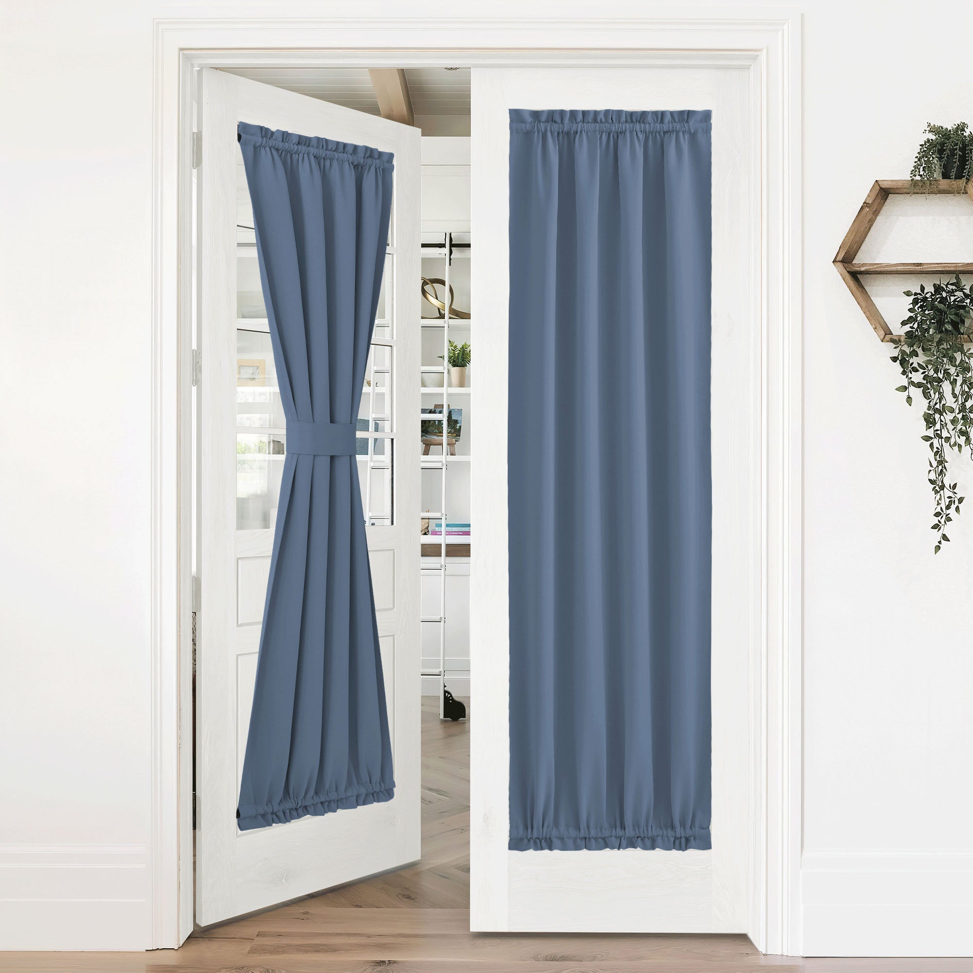Blue 50% blackout privacy door curtains on white french doors; one is tied back, the other fully extended.