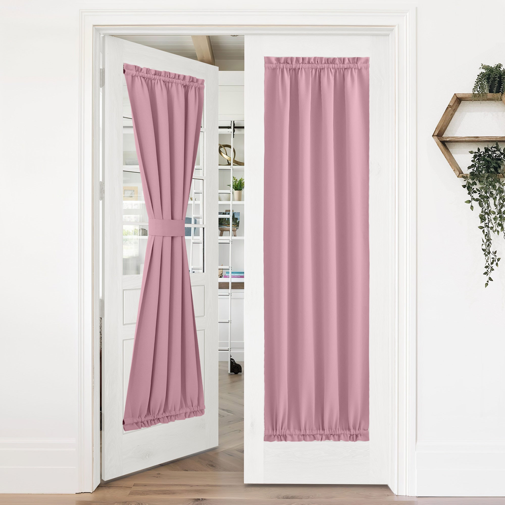 Pair of pink 50% blackout privacy door curtains on white French doors. One curtain tied back, the other closed.