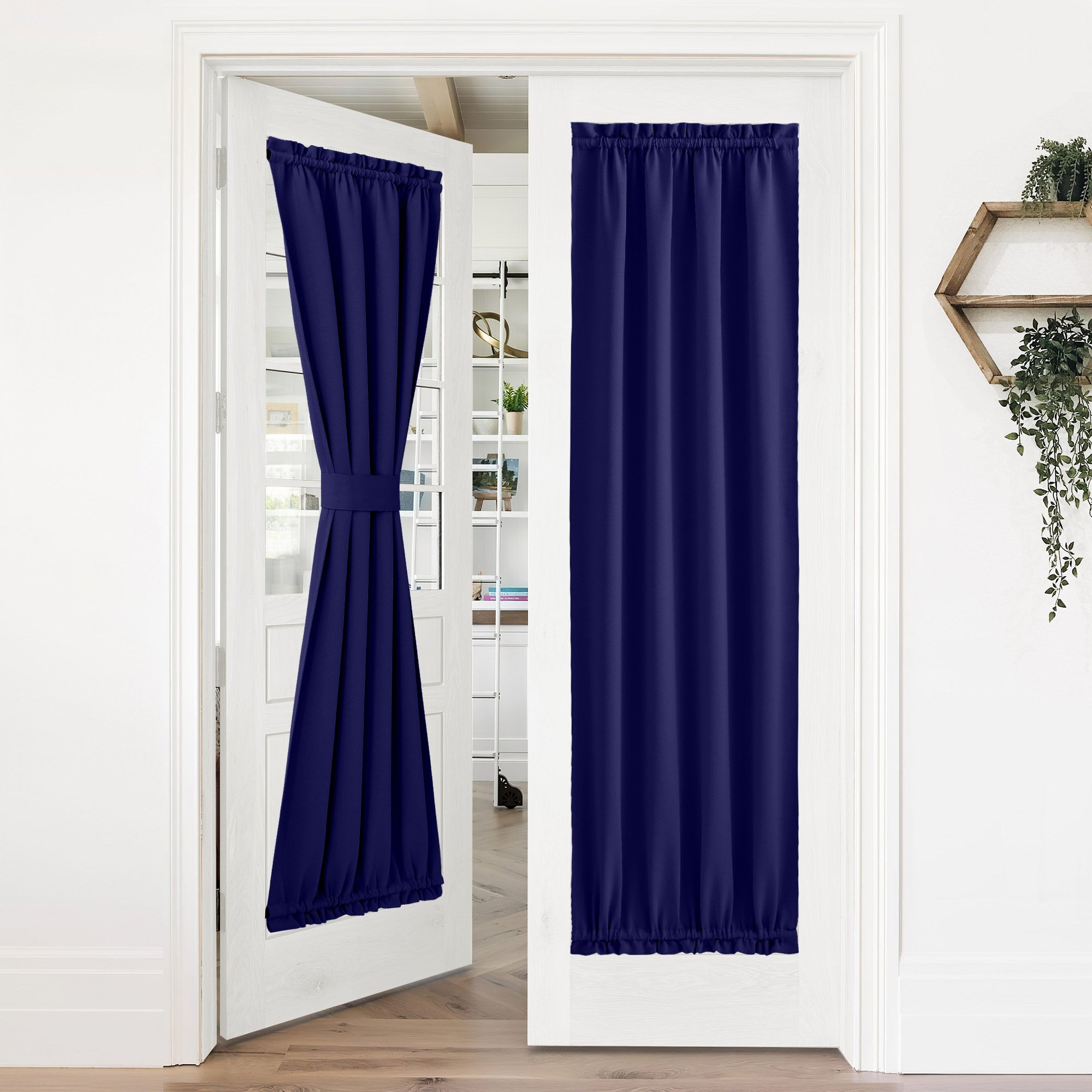 Navy blue 50% blackout privacy door curtains installed on white French doors. One tied back, the other fully closed for privacy.