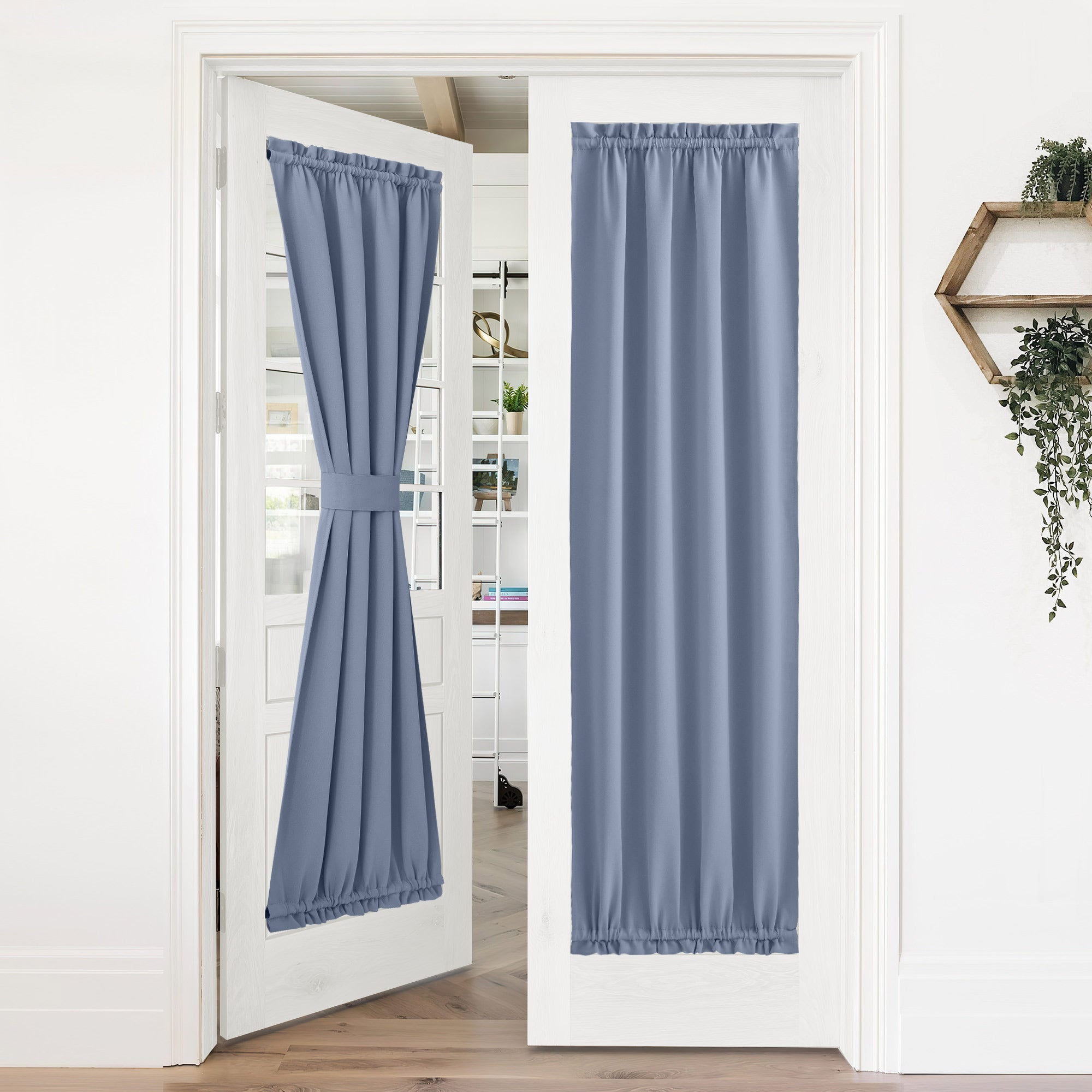 Blue 50% blackout privacy door curtains on white French doors. One curtain tied back, the other fully closed.