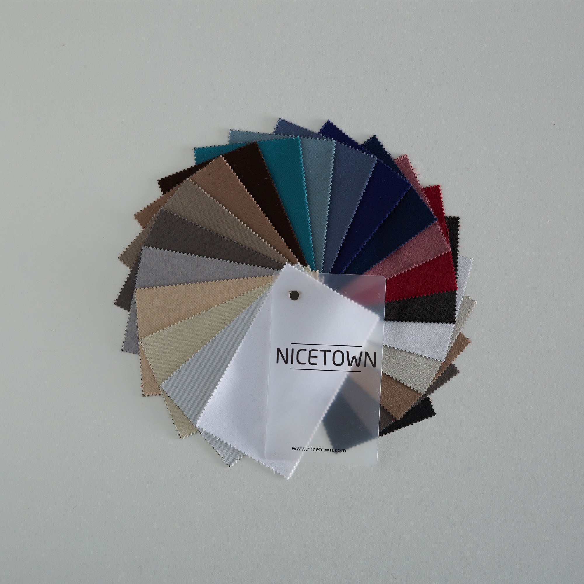 NICETOWN blackout fabric swatches display in a fan, featuring dozens of colors for custom curtains and window treatments.