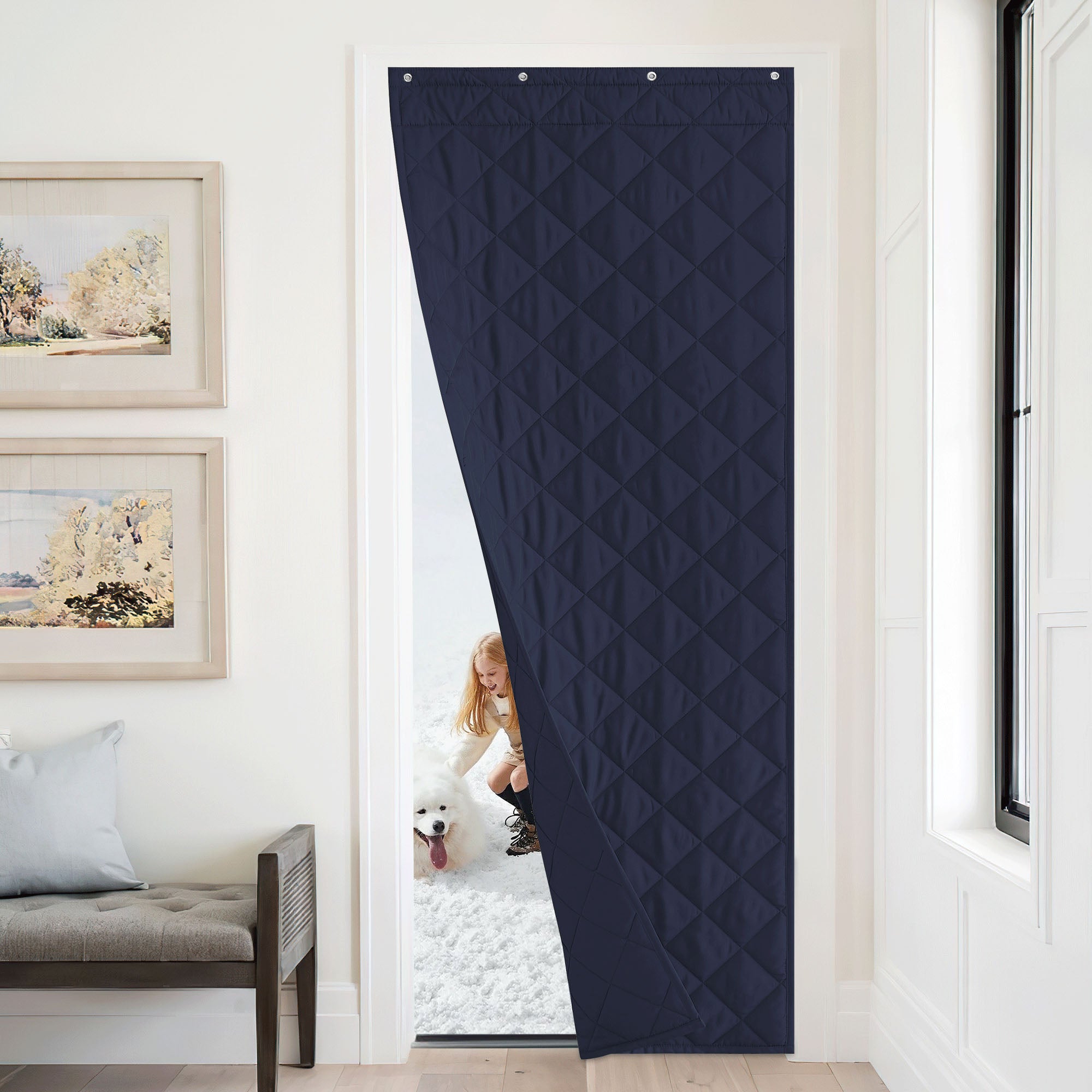 A navy blue windproof insulated curtain keeps a room warm, separating it from a snowy day outside with a child and dog.