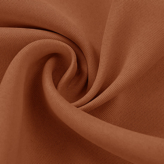 Detailed close-up of a rust brown blackout fabric swatch, highlighting its textured weave and soft, draped folds.