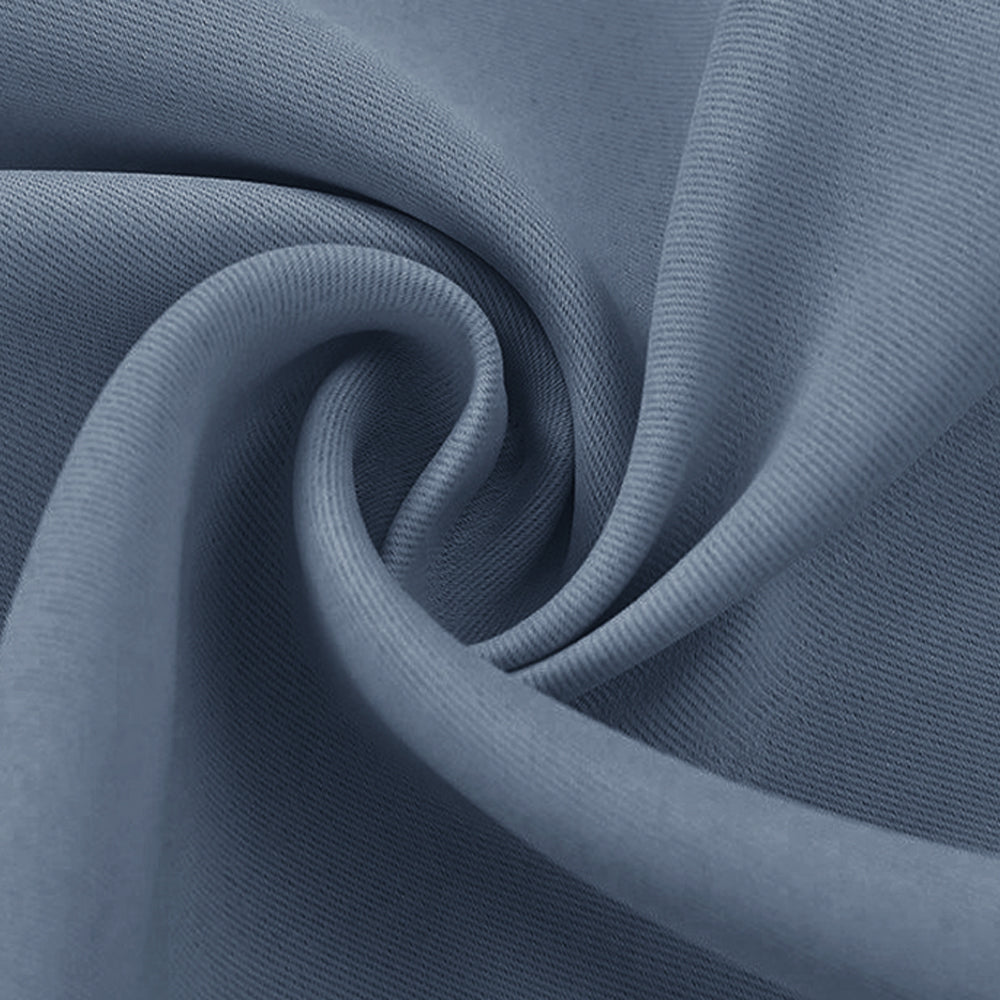 Close-up of a tightly swirled blue-grey blackout fabric swatch, highlighting its fine texture and soft drape.