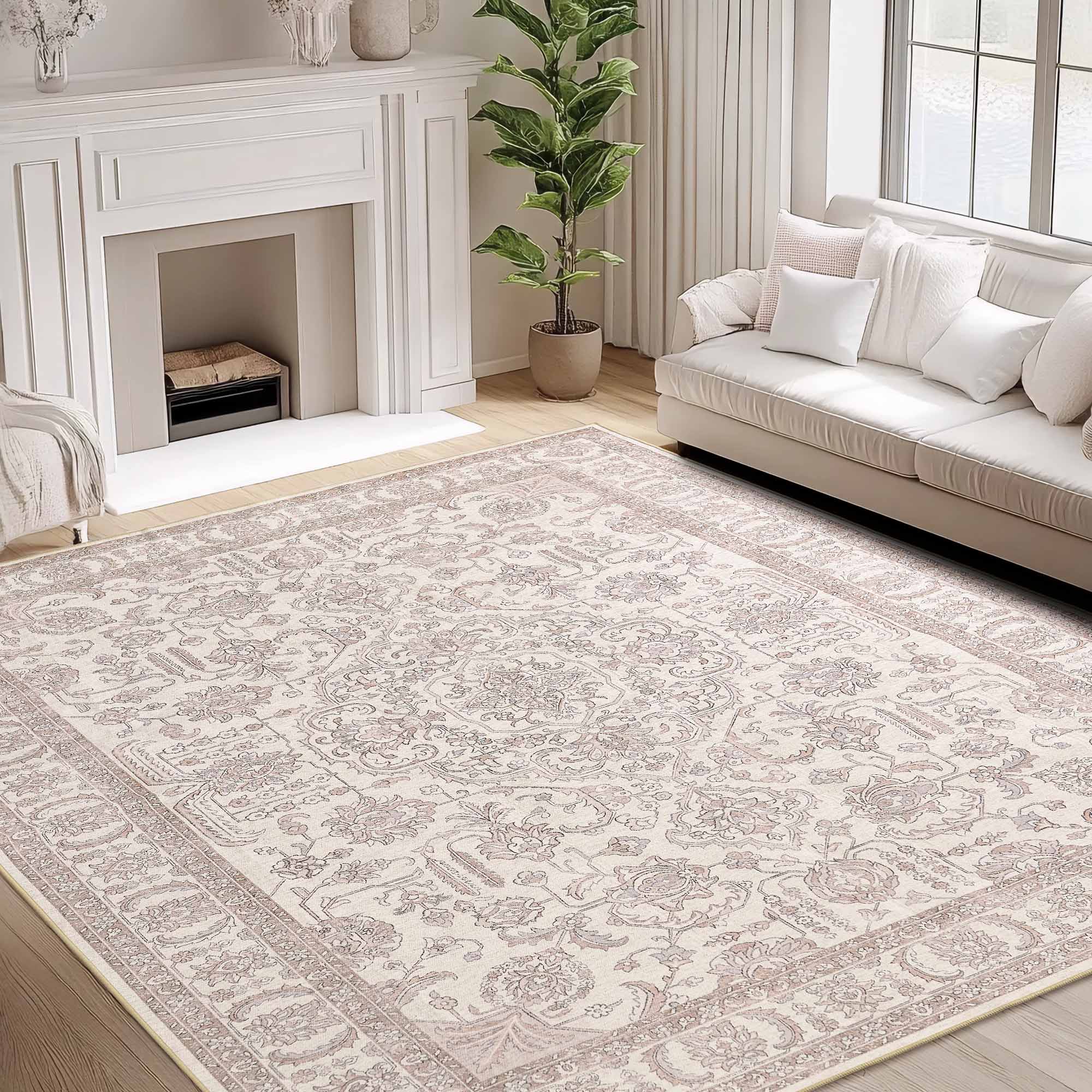 Elegant cream chenille area rug with muted pink floral medallion and border patterns, set in a cozy living room.