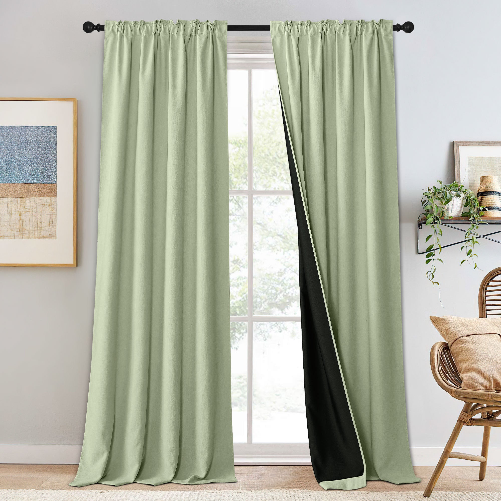 Sage green chenille blackout curtains on a black rod, one panel slightly open revealing the black room-darkening lining.