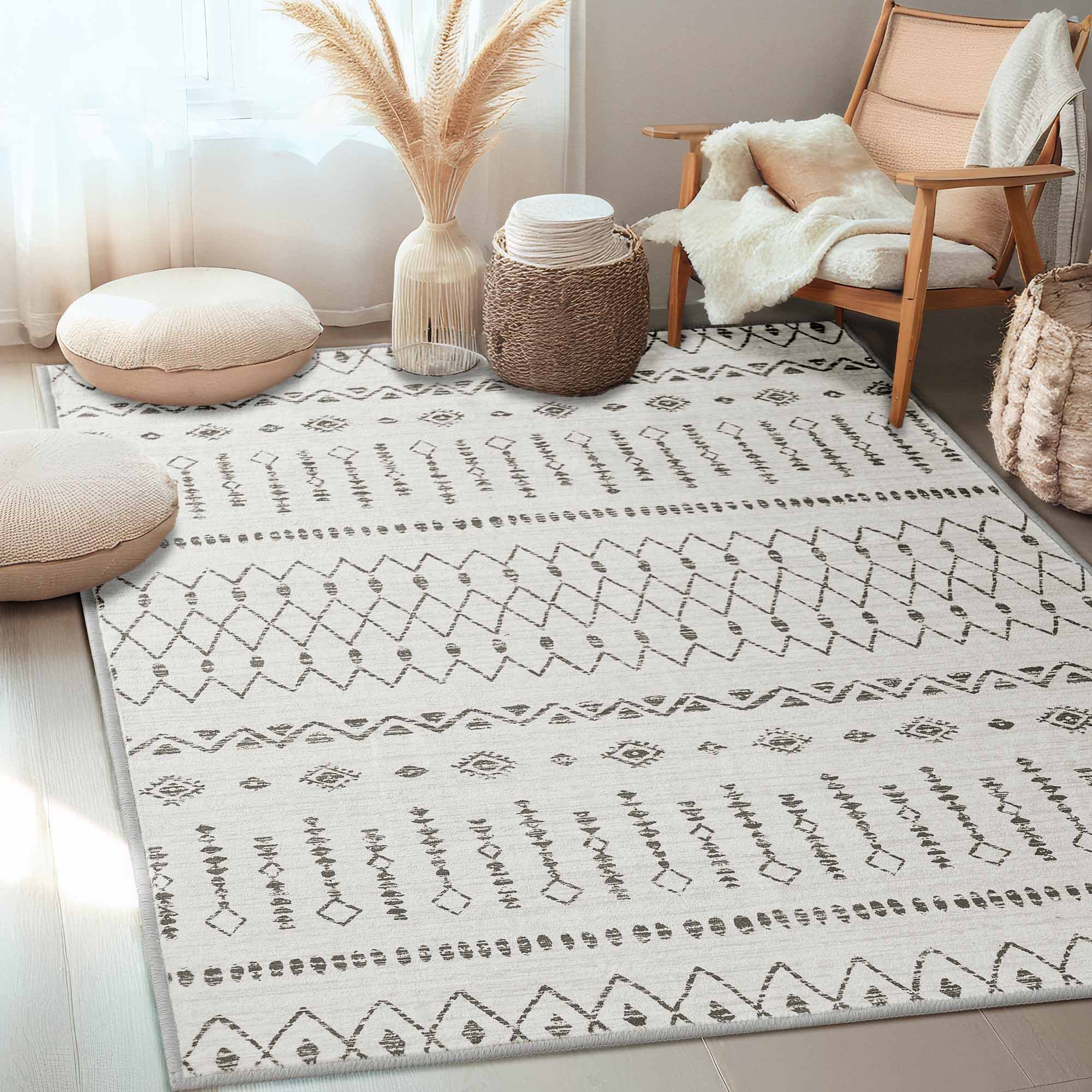 Starry Sand faux wool rug with intricate dark gray geometric patterns on light floor, flanked by cozy poufs and a wooden armchair.