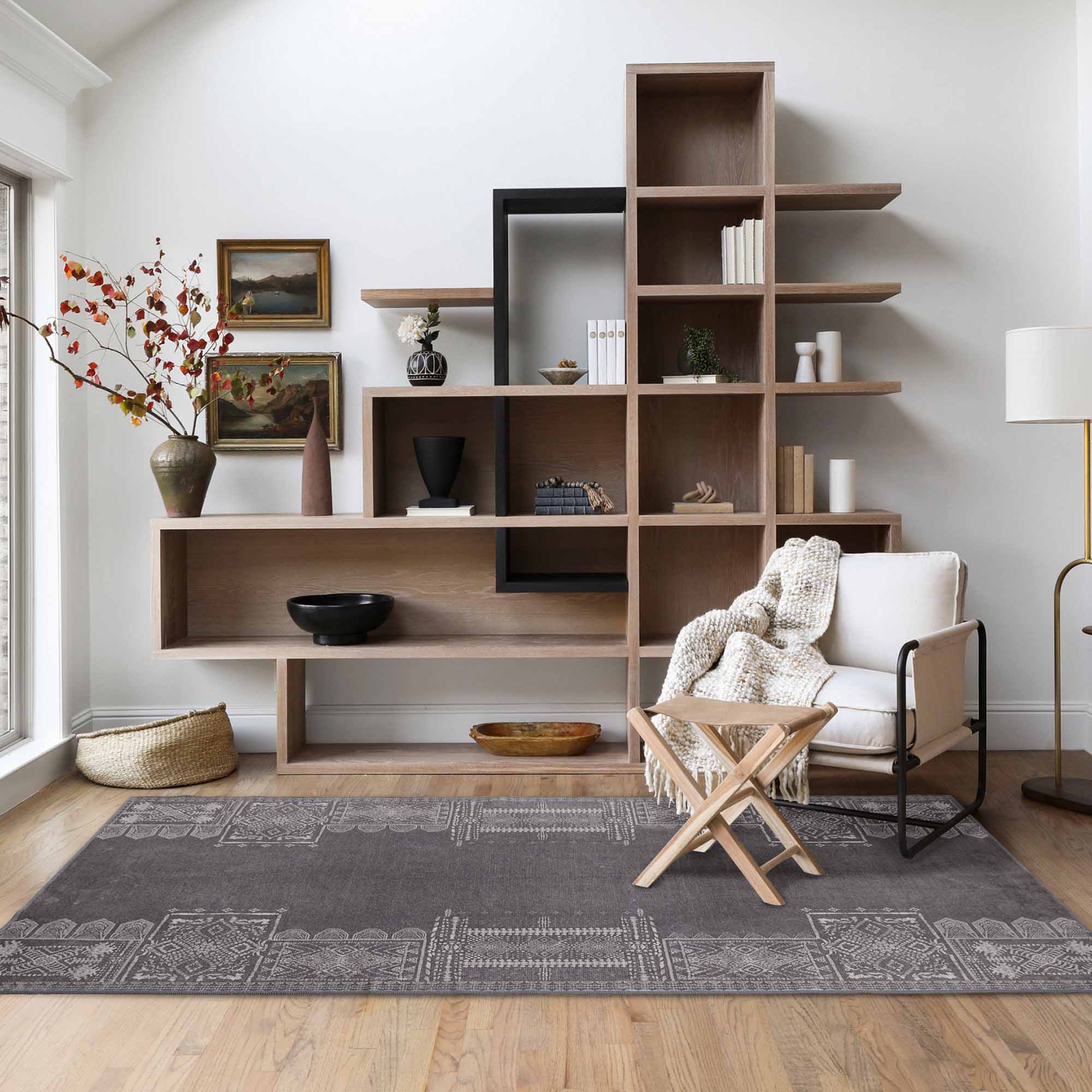 Dark grey 'Dream of Mobius' faux wool rug with light geometric patterns, grounding a stylish modern living room.