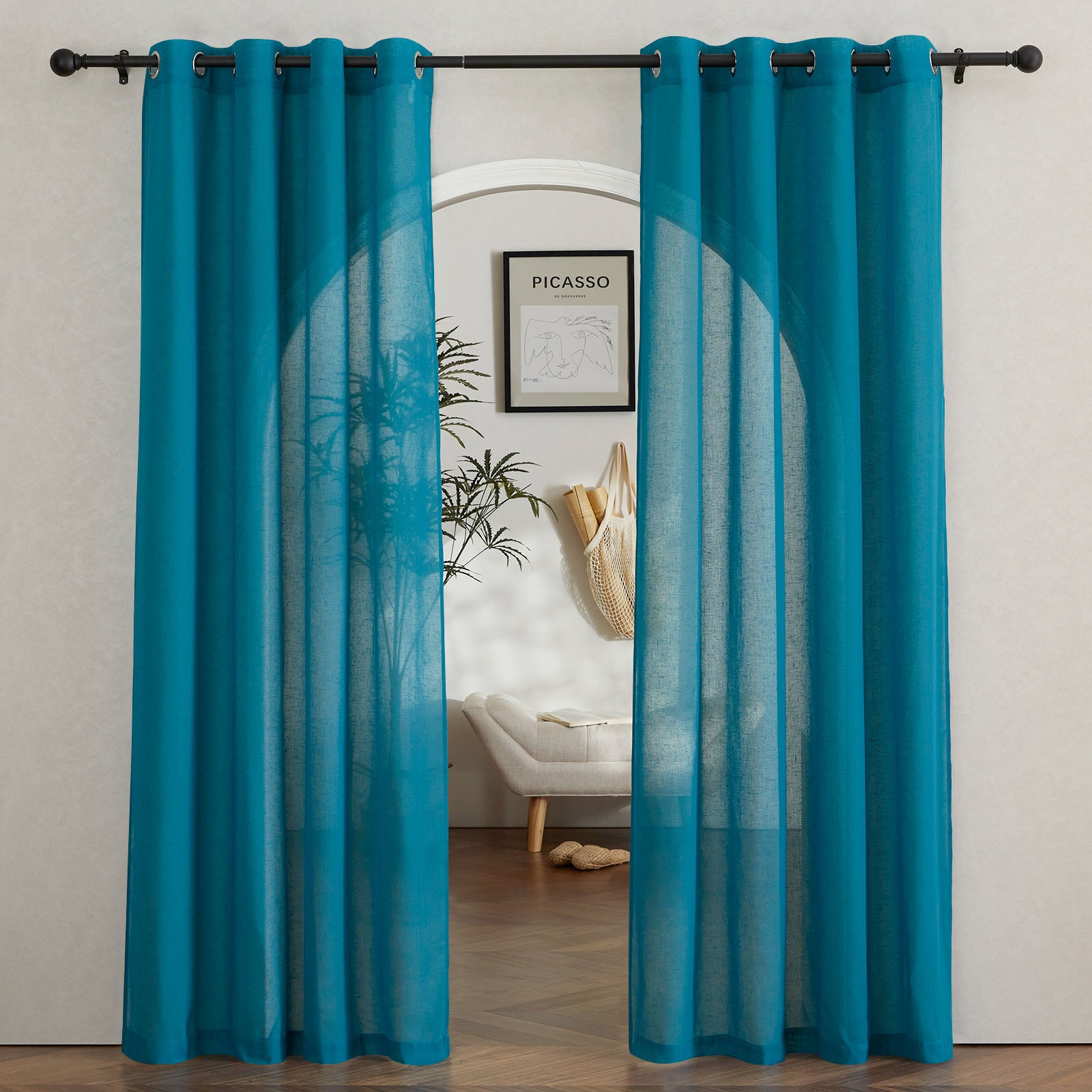 Teal faux linen sheer curtains with silver grommets hang on a black rod, framing a view through an arched doorway.
