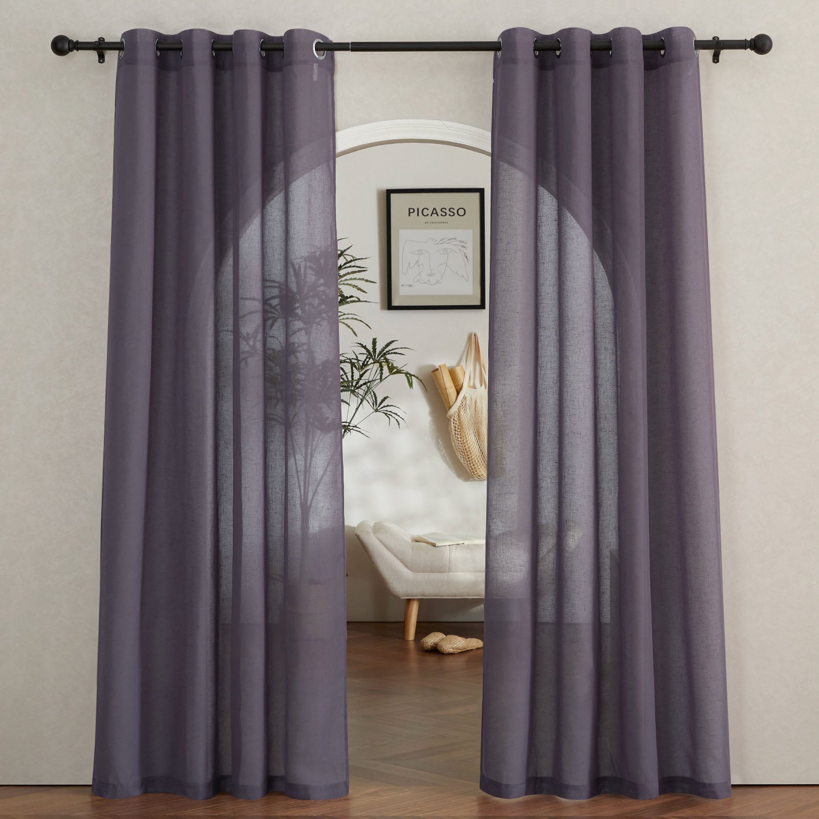 Dark purple sheer faux linen curtains with metal grommets hang on a rod, framing an arched doorway.