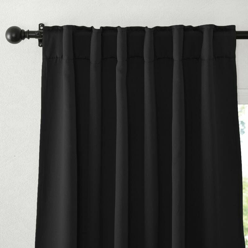 Black flame retardant curtain detail showing the rod pocket top, soft pleats, and thick blackout fabric texture.