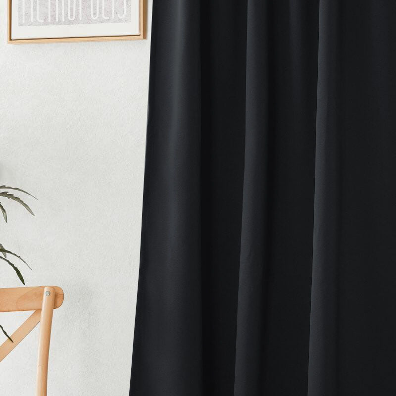 Close-up of a black flame retardant curtain, showcasing its smooth fabric texture and natural folds.
