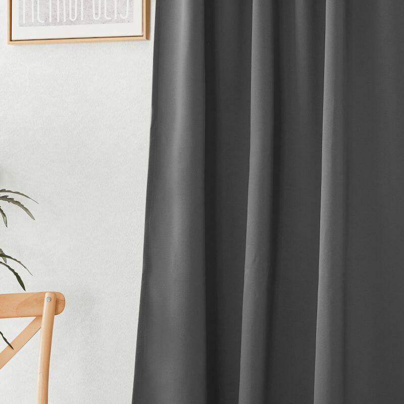 Close-up of a dark grey flame retardant curtain, highlighting the smooth fabric and elegant pleats with a subtle room background.