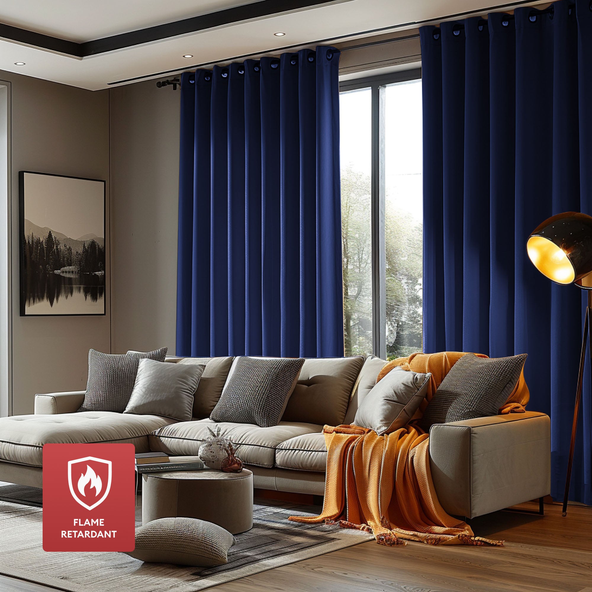 Full-length dark blue flame retardant curtains with grommets in a modern living room with a beige sectional sofa and window.