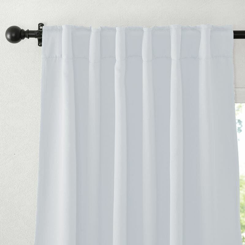 White flame retardant curtain with a neatly pleated top detail, hanging on a black decorative curtain rod.