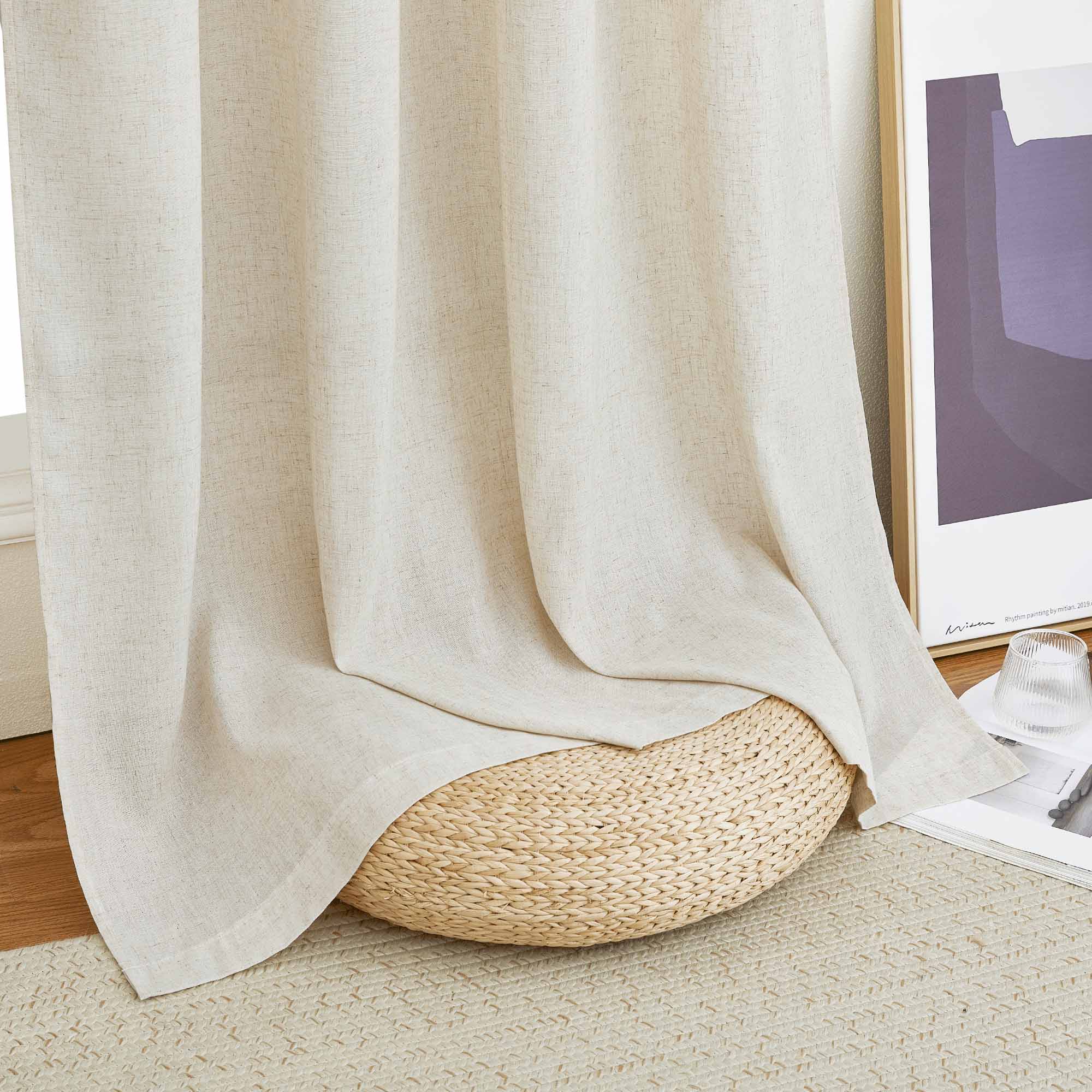Close-up of a natural linen curtain's textured fabric and bottom hem, draped elegantly over a woven floor pouf.