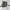 Dark green room divider curtain on a tension rod separating a bedroom from a bright, modern living room space.