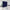 A navy blue room divider curtain creates a private bedroom space, separating it from an adjacent sunlit living area.