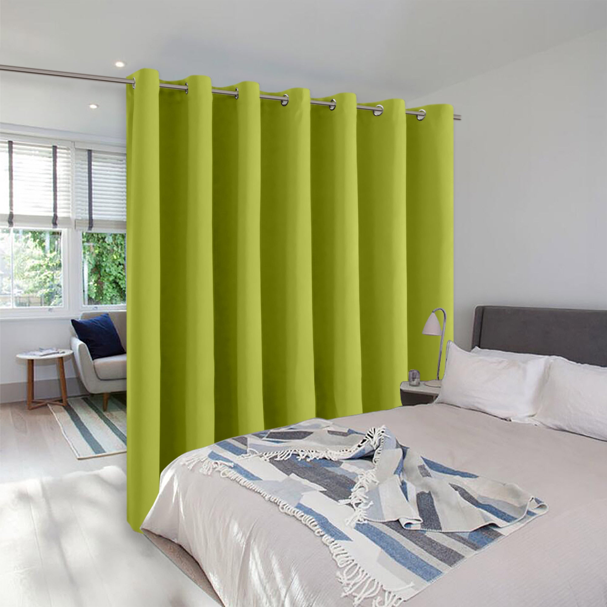 A lime green grommet room divider curtain creates privacy, separating a bedroom from a small sitting area.