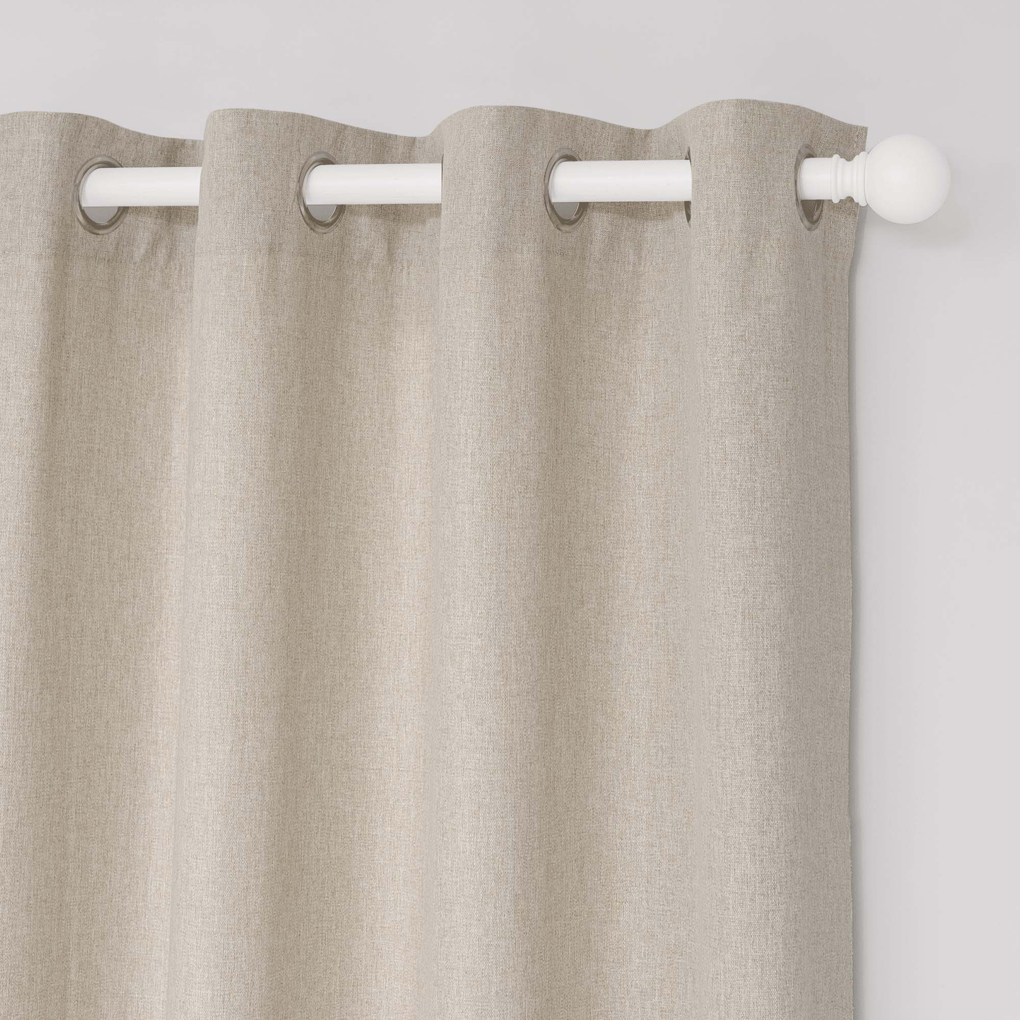 Close-up of soft cotton linen grommet curtains in light beige, showing the fabric texture and a white curtain rod.