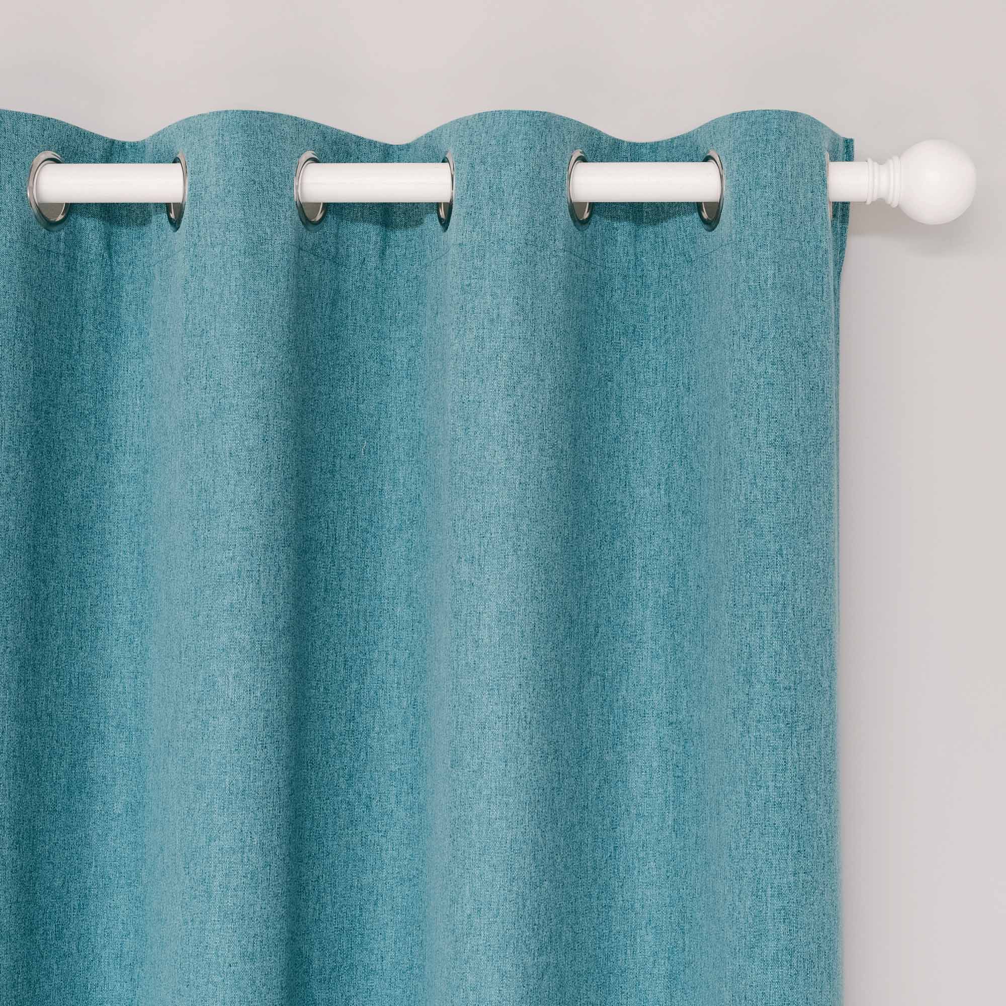 Close-up of a teal blue soft cotton linen curtain with silver grommets on a white rod, showing the fabric texture.