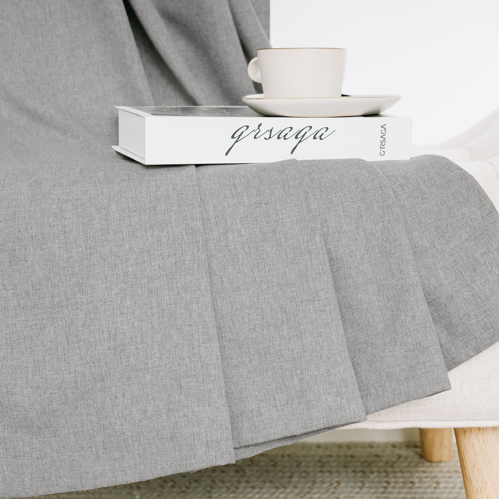 Soft grey cotton linen curtain draped naturally over a chair, showing its rich texture and relaxed feel.