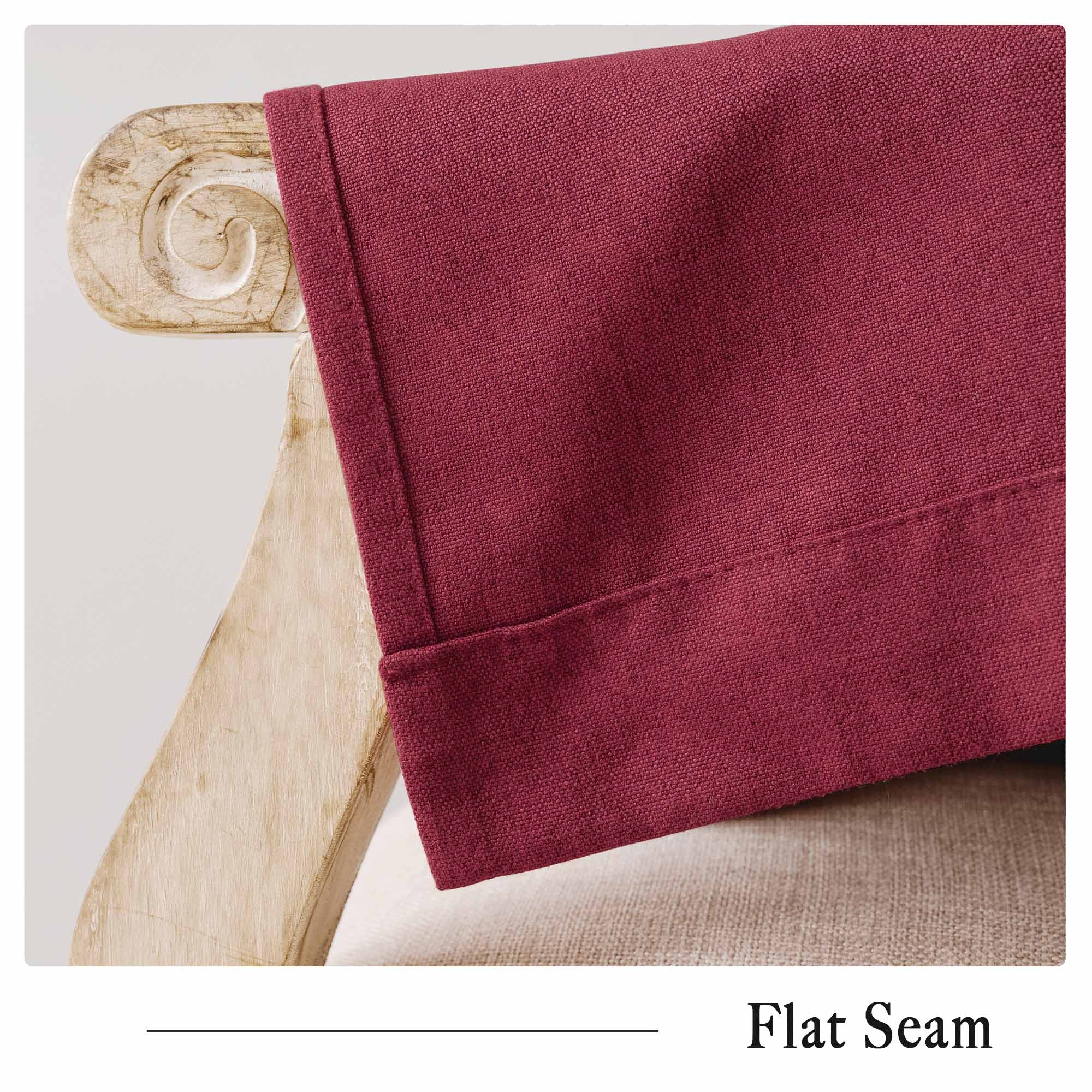 Close-up of red soft cotton linen curtain fabric showcasing the flat seam detail and rich texture, draped over a wooden chair.