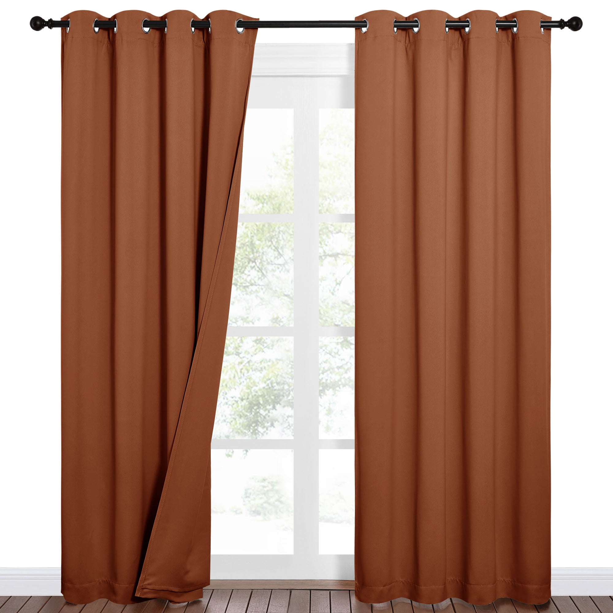 Rust brown 100% blackout curtains with grommet tops on a black rod, partially open to show a window.