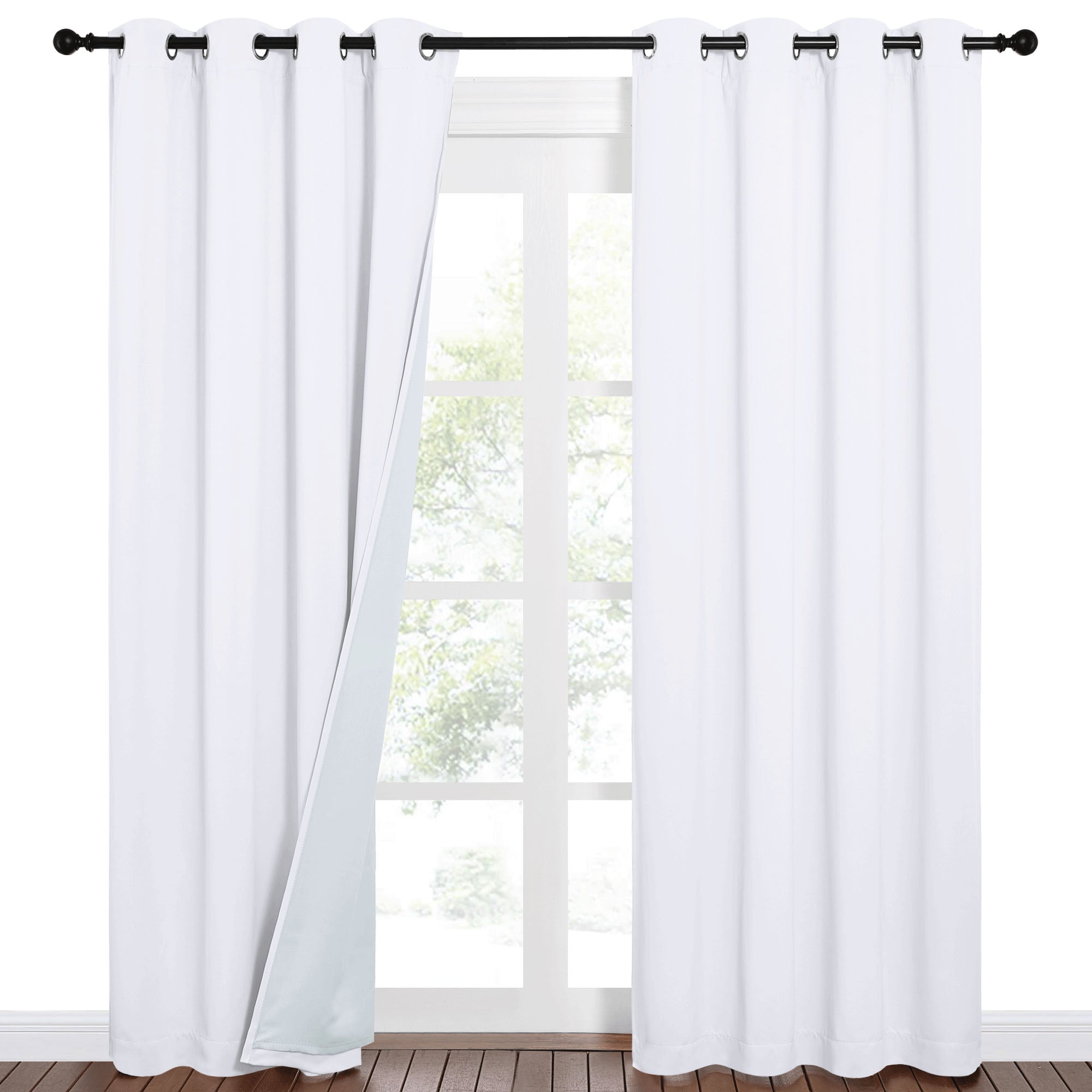 White 100% blackout sound barrier grommet curtains on a black rod, one panel slightly open revealing the thick lining and window.