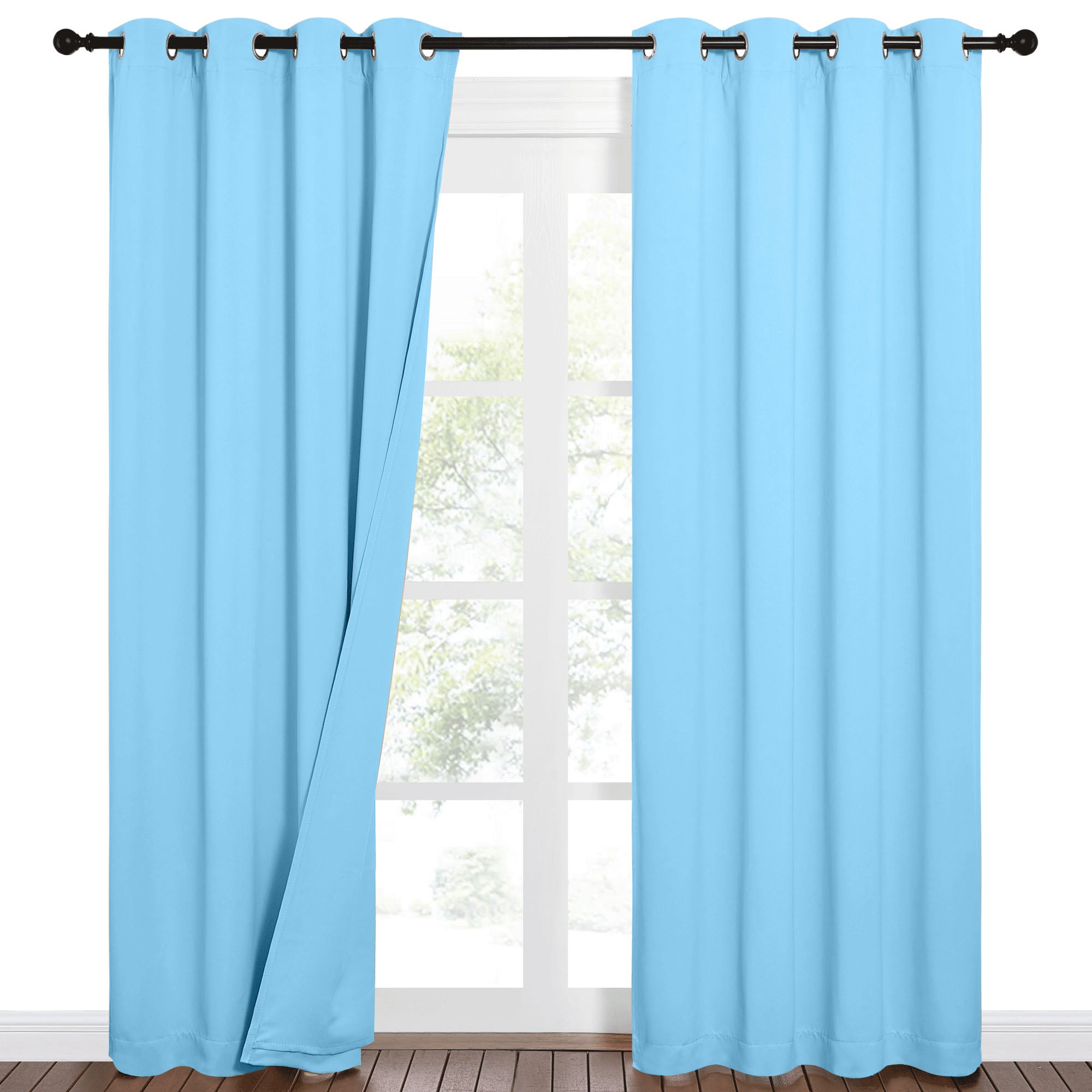 Light blue grommet top blackout curtains, one panel partially open revealing a window view.