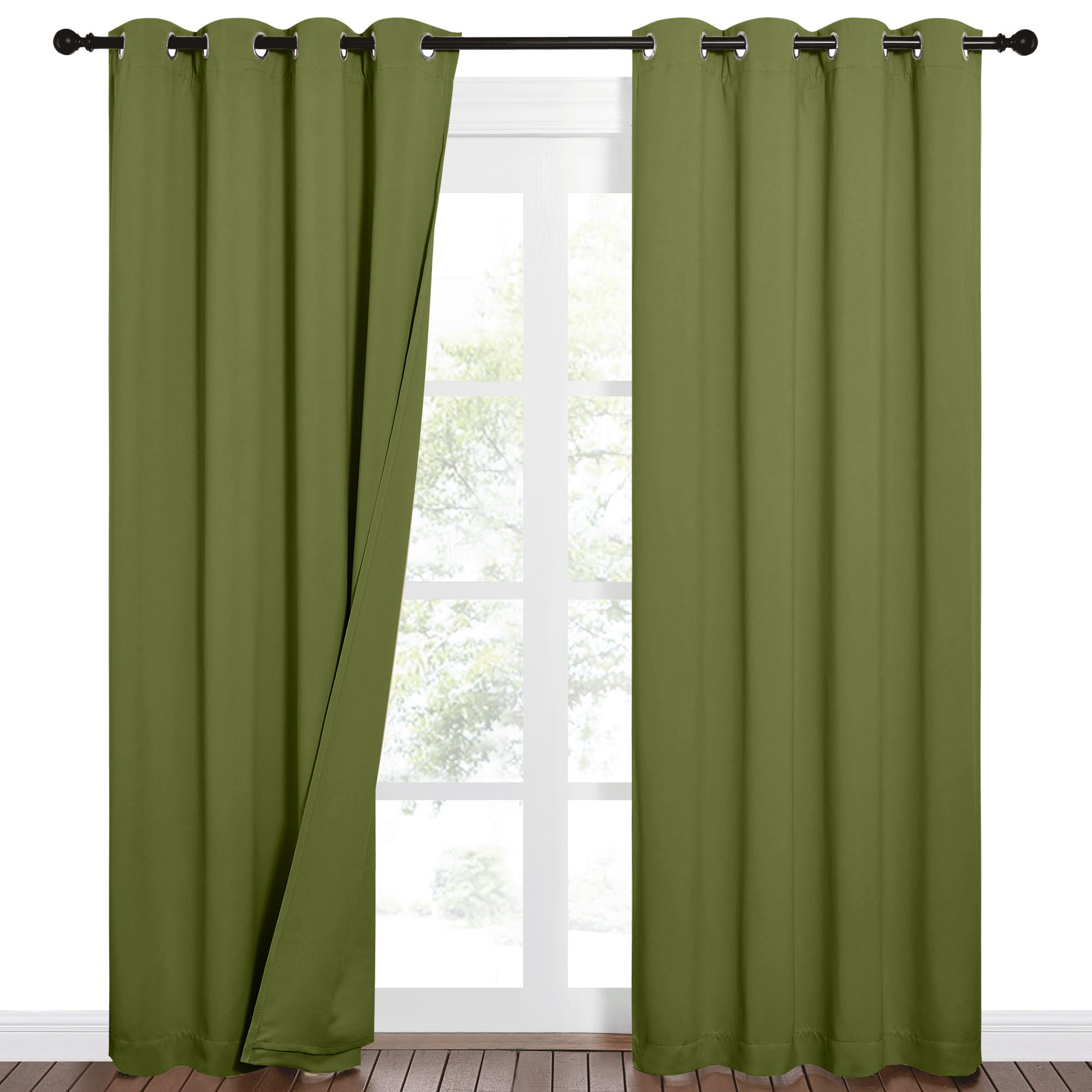 Pair of olive green sound barrier blackout curtains with grommets, one panel drawn back slightly to show a window and trees.