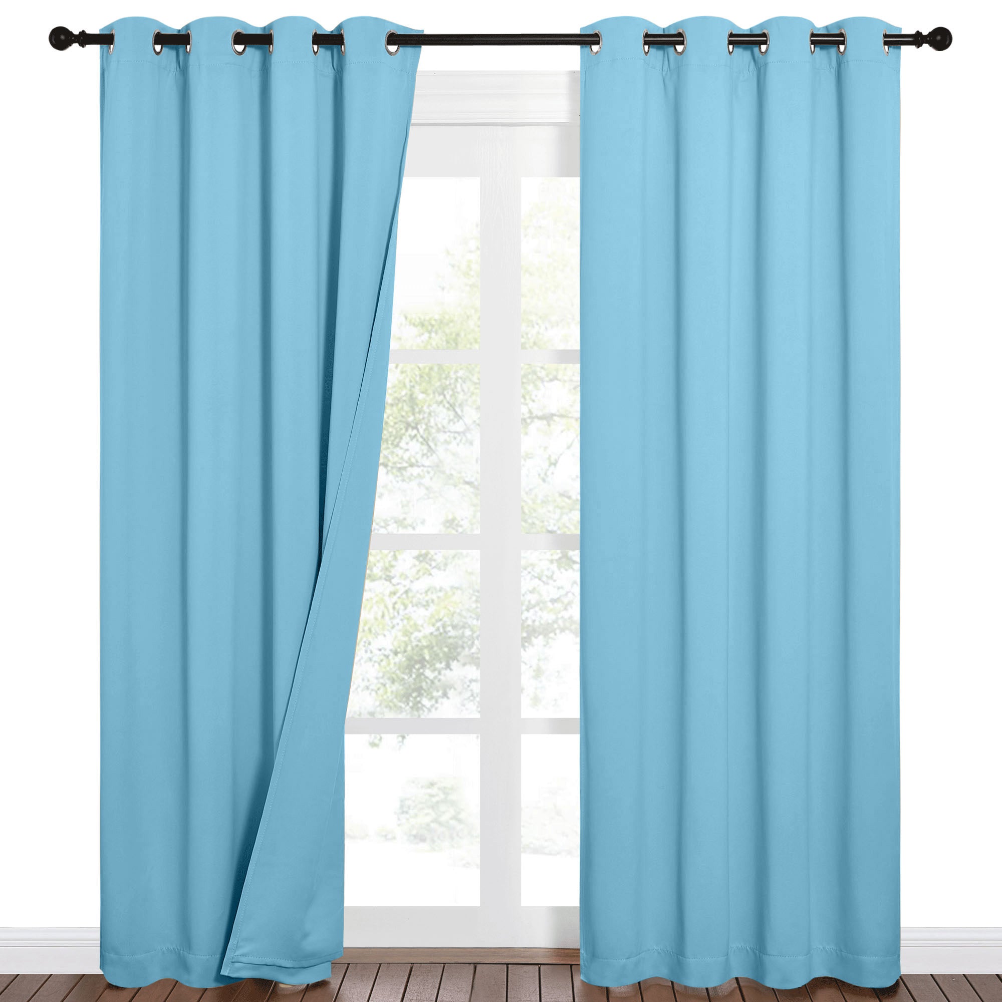Aqua sound barrier 100% blackout curtains with grommet tops, one panel slightly open over a window with a green outdoor view.
