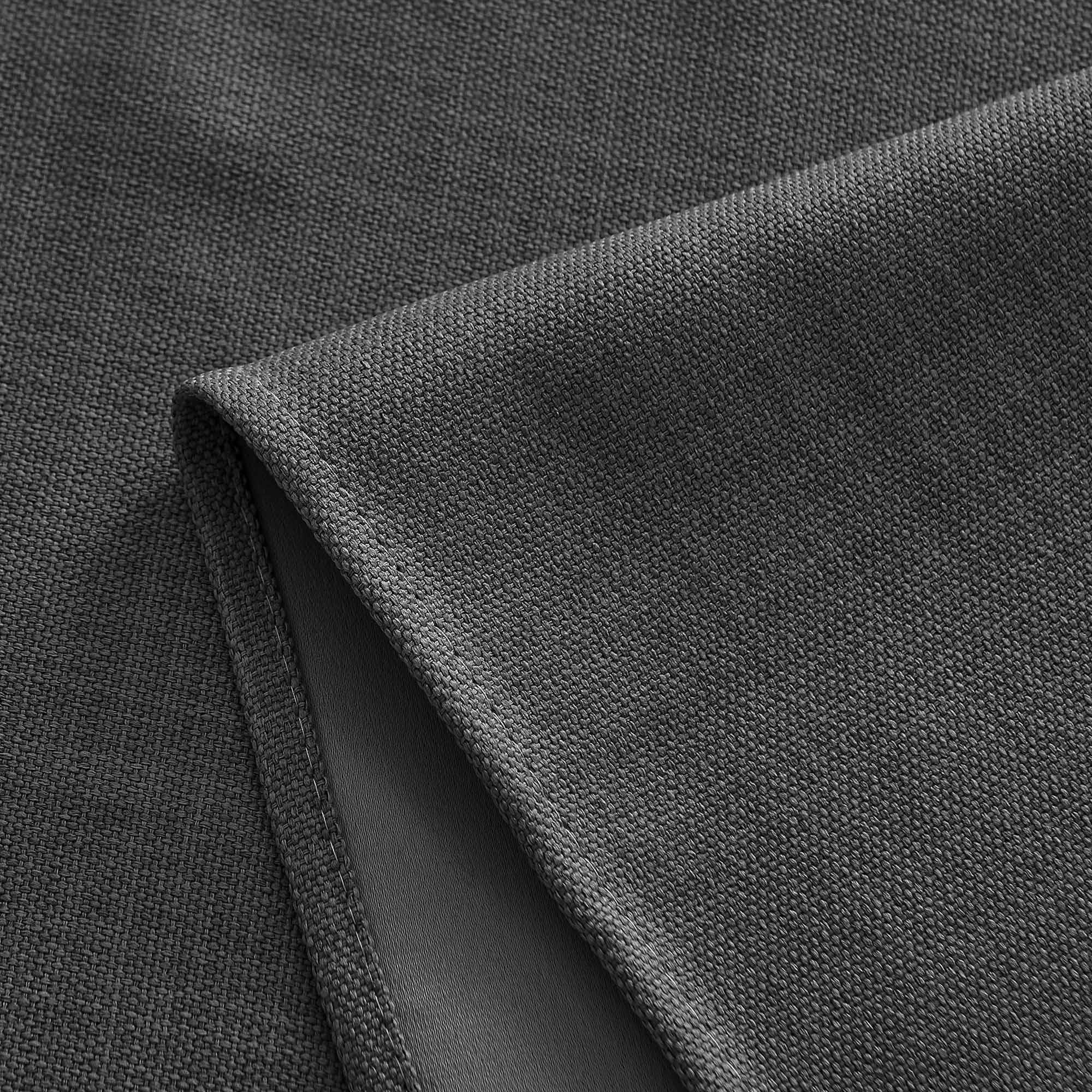 Close-up of dark grey tablecloth fabric showing woven texture and neatly stitched edge detail.