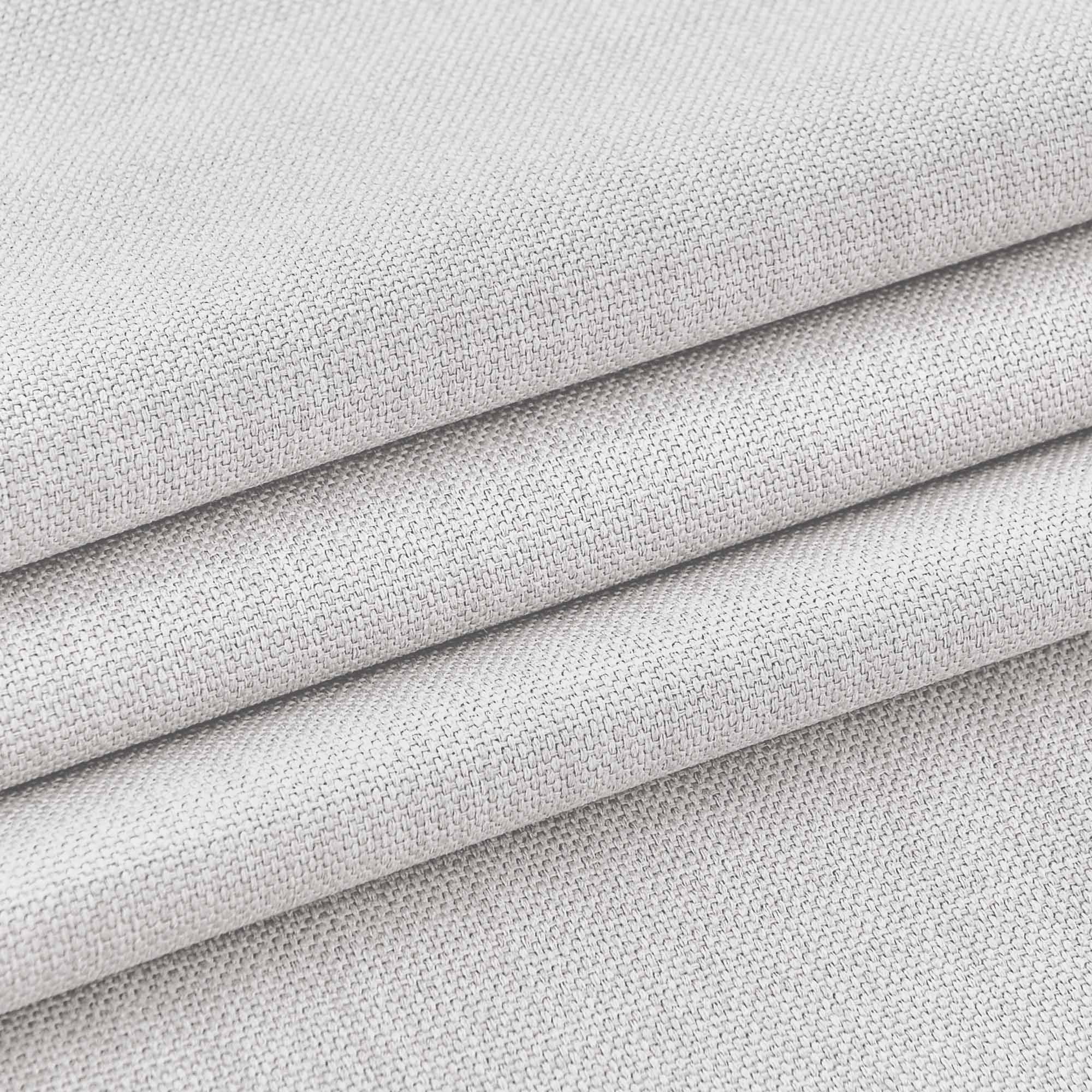 Close-up of a light grey woven tablecloth fabric, highlighting its detailed texture and soft folds.