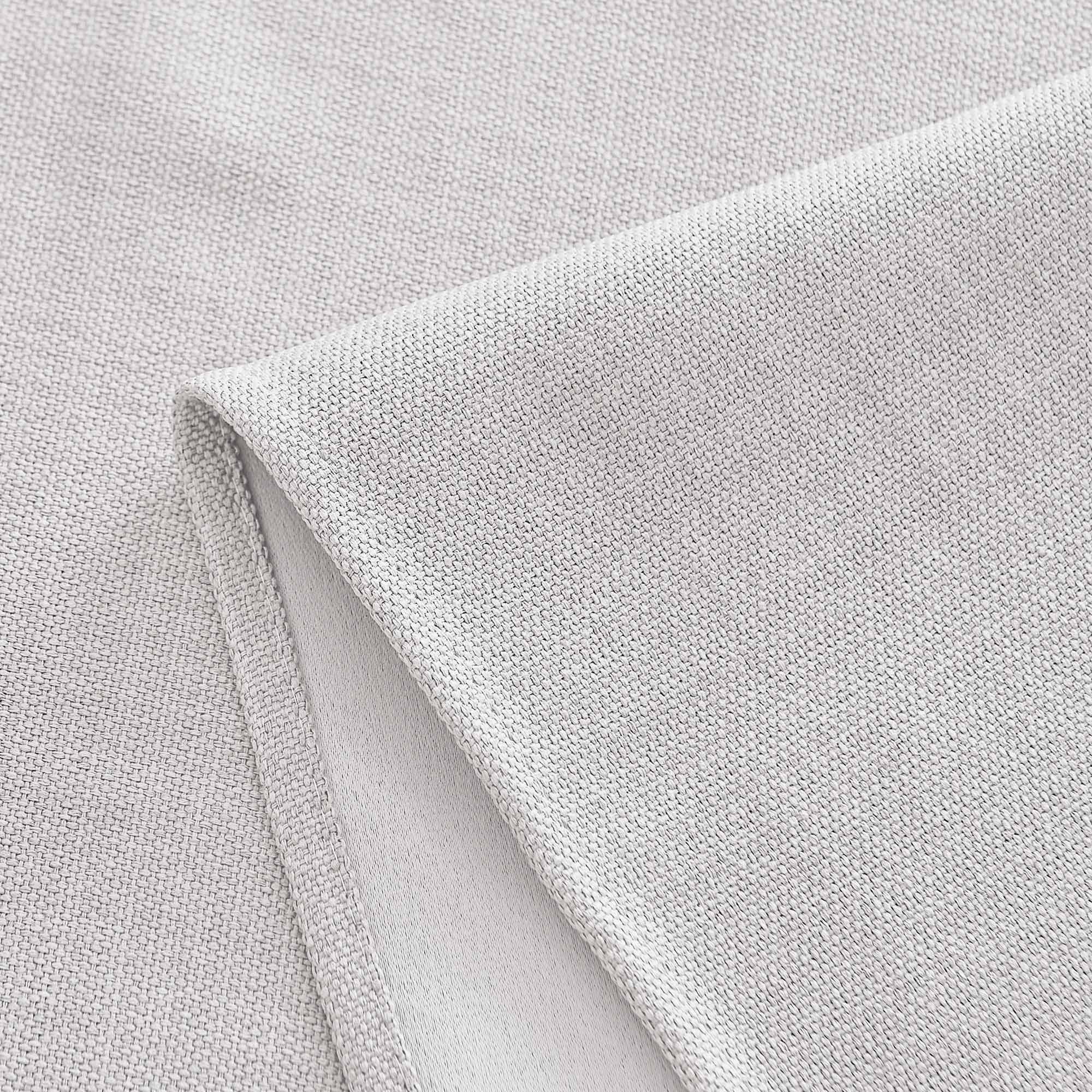Close-up of a light grey woven tablecloth fabric, showing fine texture and a neatly folded edge.