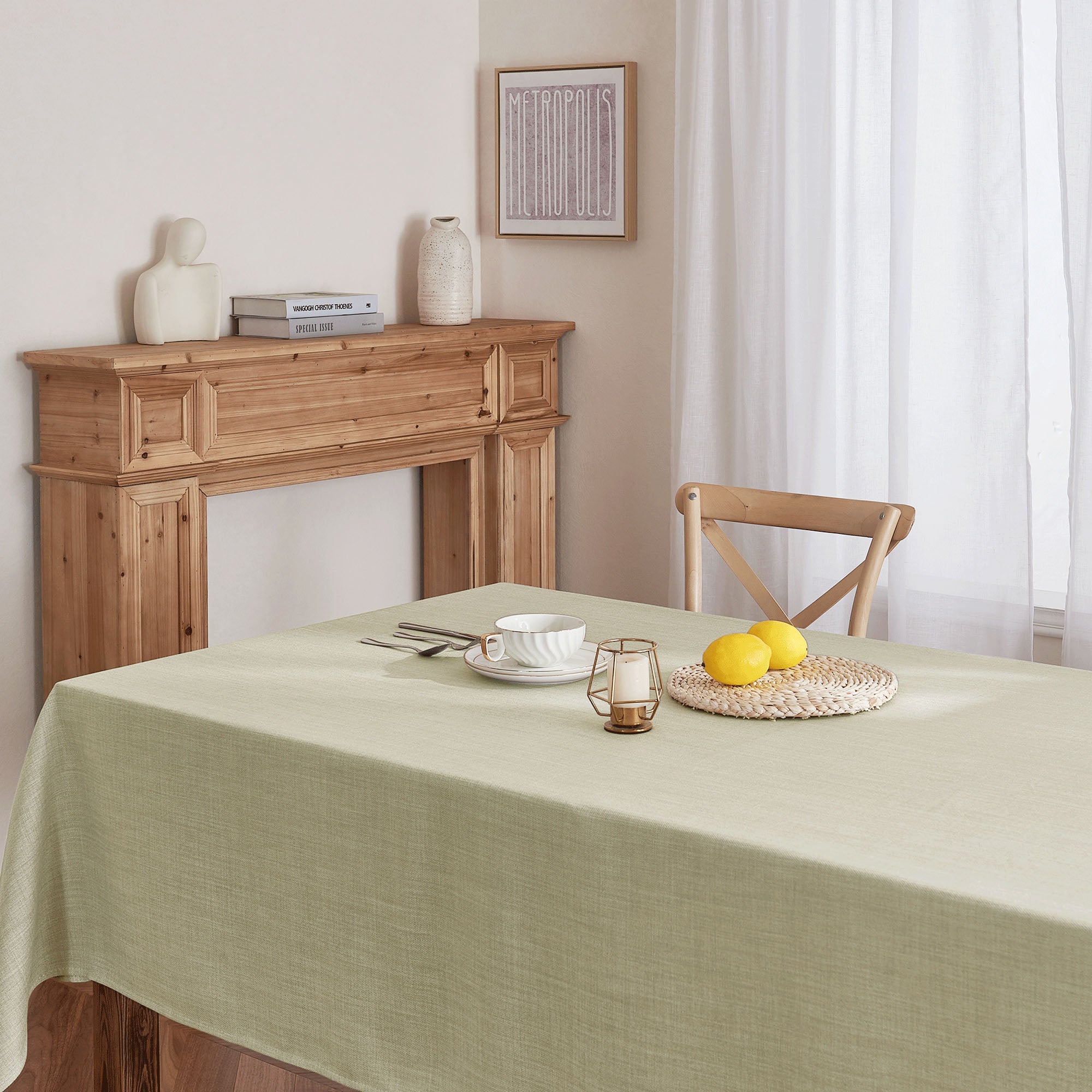 Textured light green tablecloth on a dining table with a teacup, candle lantern, and lemons, creating a fresh home decor scene.