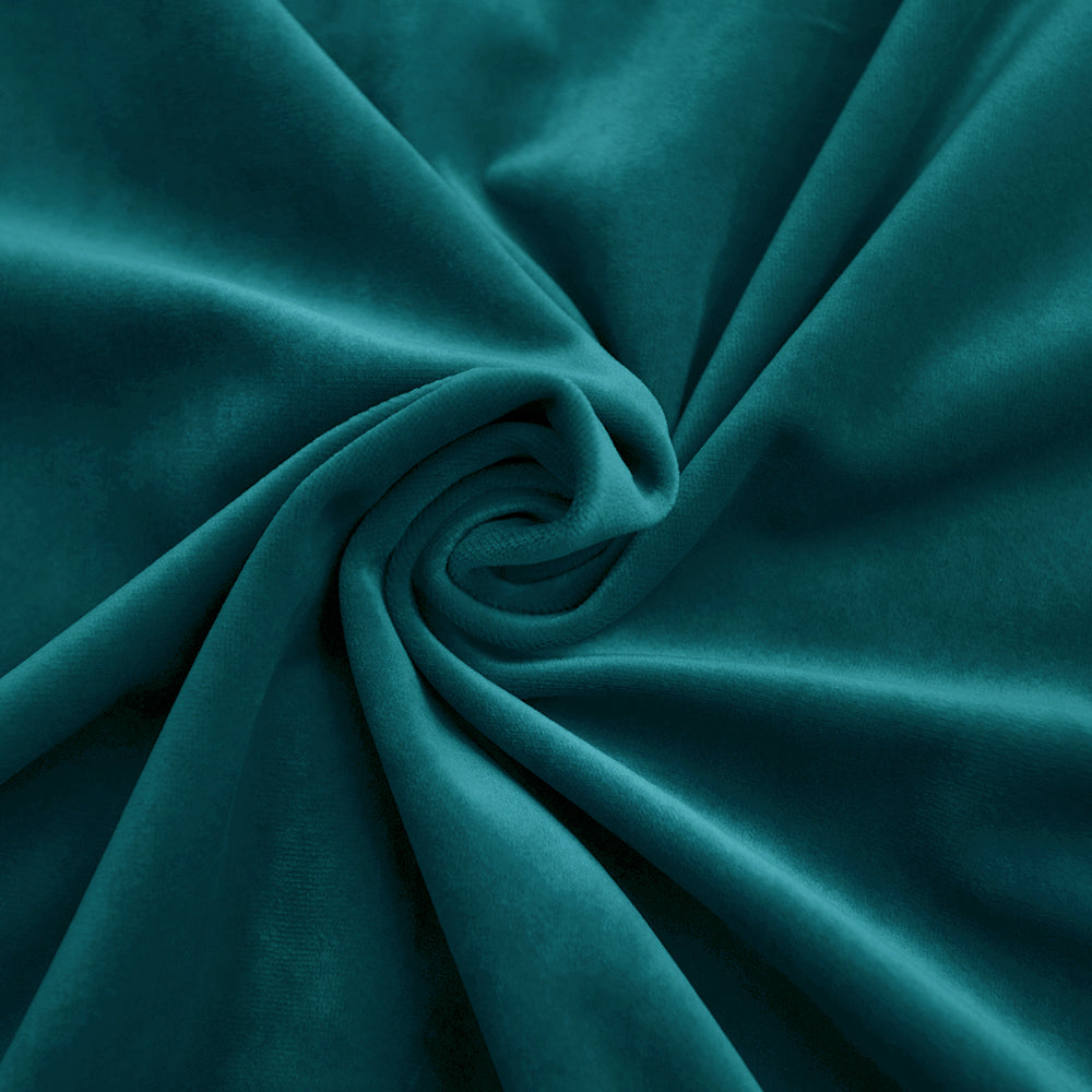 Close-up of luxurious teal velvet fabric, swirled to highlight its soft texture and rich color.