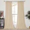 Two floor-length beige velvet curtains hanging on a gold rod, framing a window in a contemporary living room.
