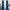 Full view of long blue velvet curtain panels hanging on a gold rod, framing a window and pooling elegantly on the floor.