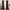 A pair of long, brown velvet curtains hanging on a brass rod, framing a tall window in a bright, modern room.