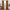 A pair of floor-length rust velvet curtains hang on a gold rod, framing a window in a modern living room.