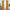 A pair of long mustard yellow velvet curtains hanging from a gold rod, framing a tall window in a brightly lit room.